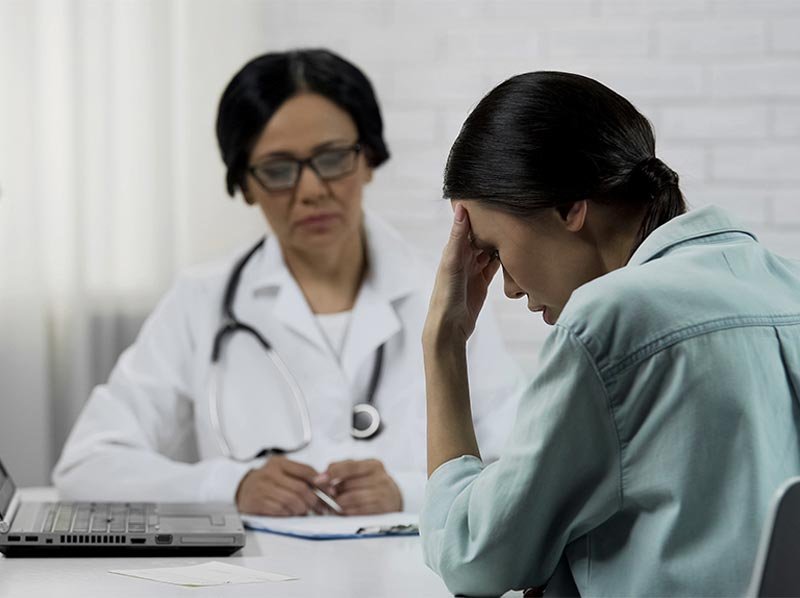 woman in distress talking to doctor